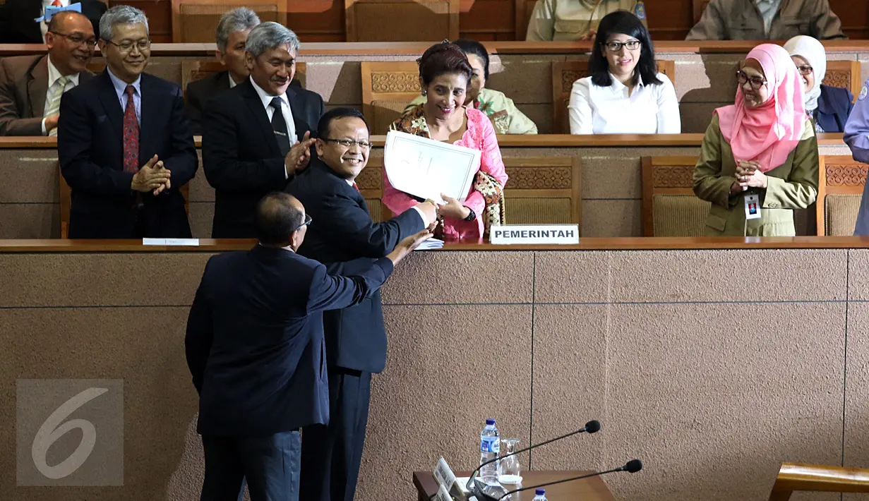 Menteri Susi Pudjiastuti (tengah) berjabat tangan dengan ketua Komisi IV Edie Prabowo usai menyerahkan pandangan pemerintah dalam Sidang Paripurna DPR di Gedung DPR, Jakarta, Selasa (15/3/2016). (Liputan6.com/Johan Tallo)