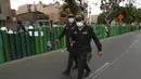 Polisi membantu menjaga ketertiban di luar toko isi ulang tangki oksigen di Callao, Peru, Senin (25/1/2021). Di tengah pandemi COVID-19, beberapa orang mengatakan mereka telah antre sehari sebelumnya untuk menjadi yang pertama saat toko buka. (AP Photo/Martin Mejia)