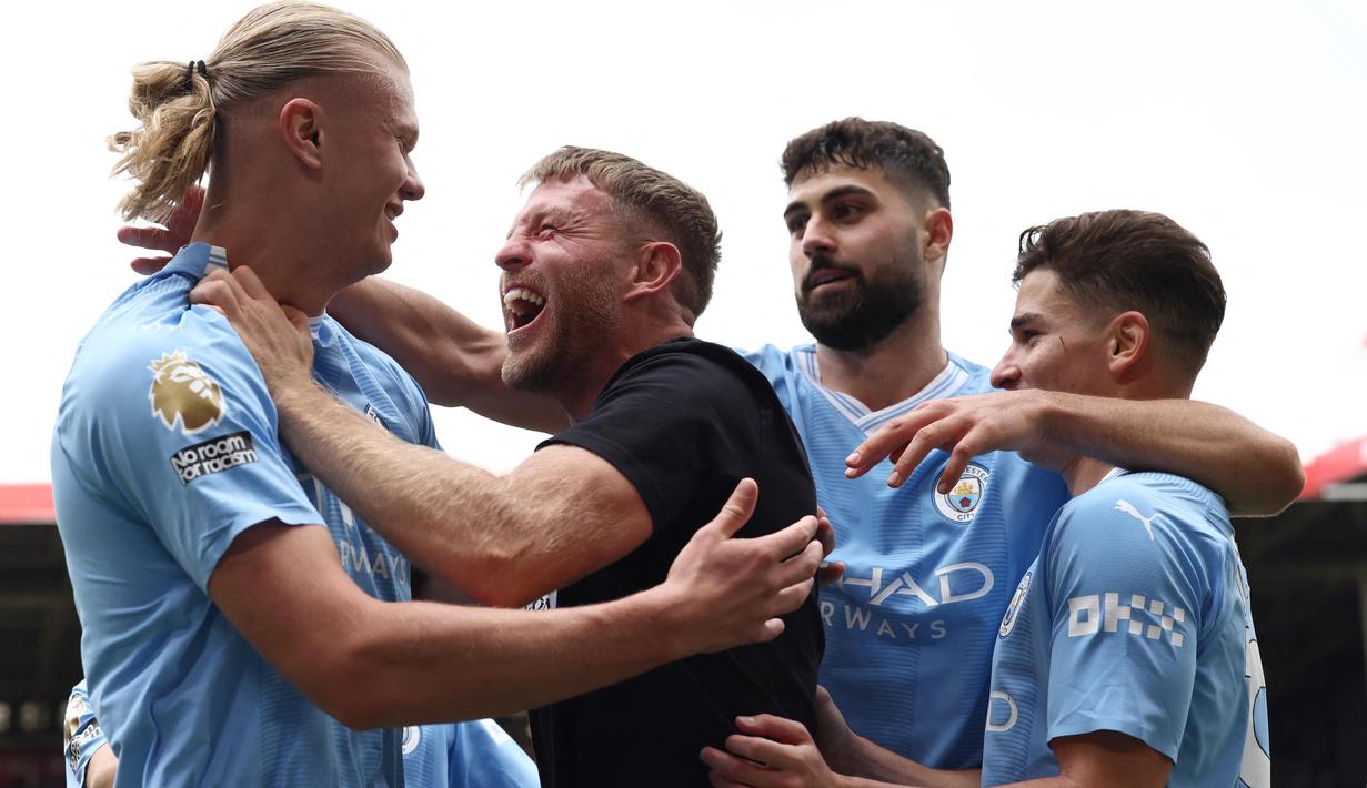 Kehadiran Terry Flanangan tak membuat Erling Haaland dan beberapa rekan satu timnya terganggu. Mereka terlihat menikmati momen kebahagian bersama walau tak berselang lama petugas keamanan langsung mengamankan sang pitch invader. (AFP/Darren Staples)