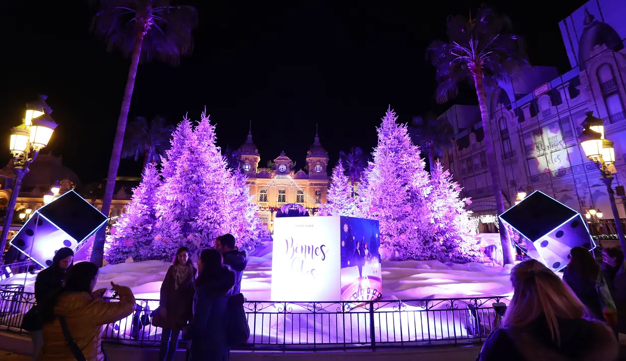 Orang-orang mengunjungi lampu dan dekorasi untuk menyambut Natal yang dipajang di depan Kasino Monte-Carlo di Monako pada 7 Desember 2018. (Photo by VALERY HACHE / AFP)