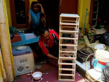 Warga membersihkan perabot rumah tangga dari sisa endapan lumpur di depan rumahnya pasca-banjir di Kawasan Jatinegara Barat, Jakarta Timur, Rabu (5/3/2025). (Liputan6.com/Herman Zakharia)