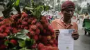Seorang pedagang buah rambutan menunjukkan surat pernyataan saat ditindak oleh Petugas Dinas Perhubungan di Car Free Day (CFD) di kawasan Bunderan HI, Jakarta, Minggu (4/2). (Liputan6.com/Faizal Fanani)