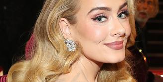 Adele terlihat segar dan modern dengan warna berry yang romantis. Ia merias kelopak mata, pipi, dan bibirnya dengan cantik. Foto: Glamour.