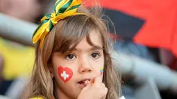 Sambil menikmati makanan kecil, pendukung muda "Scweizer Nati" setia menunggu dimulainya laga Swiss kontra Ekuador di Estadio Nacional de Brasilia, (15/6/2014). (AFP PHOTO/Adrian Dennis)