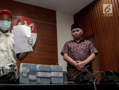 Petugas bersama Ketua KPK Agus Rahardjo (kanan) menunjukkan barang bukti hasil operasi tangkap tangan (OTT) di gedung KPK, Jakarta, Jumat (5/1). (Liputan6.com/Faizal Fanani)