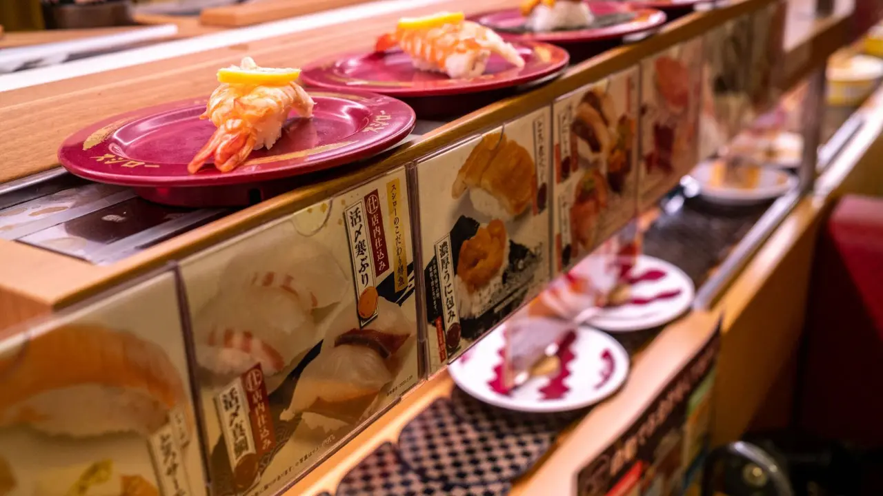 Piring sushi terlihat di ban berjalan di rantai restoran sushi Jepang.