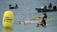 Para peserta bertanding sambil ditonton oleh kru pendukung dalam kompetisi renang Oceanman Bali 2021 di sebuah pantai di Sanur, Denpasar, Bali, Sabtu (18/9/2021). Oceanman Bali 2021 akhirnya sukses digelar setelah beberapa kali ditunda. (SONY TUMBELAKA/AFP)