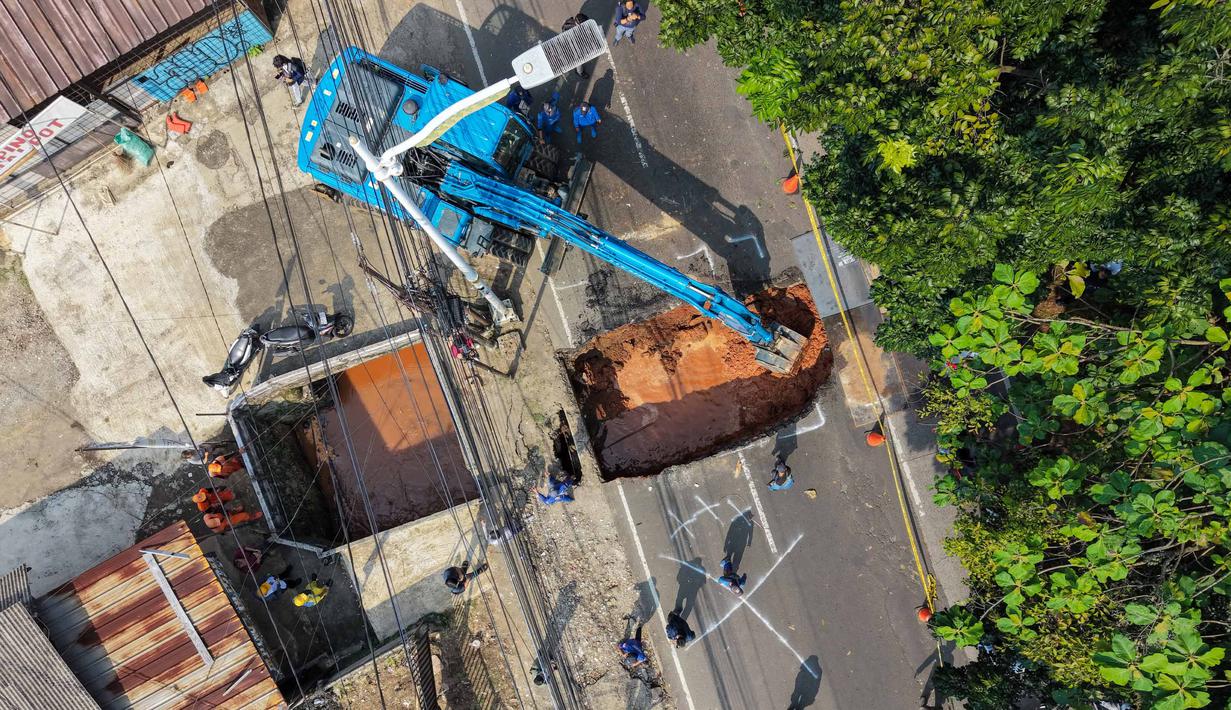 Foto udara menunjukkan aktivitas para pekerja menggunakan alat berat untuk membersihkan puing-puing dari lubang runtuhan yang terbentuk di Jalan Raya Lenteng Agung (arah Depok), Jakarta pada Jumat 29 Mei 2026. (BAY ISMOYO/AFP)