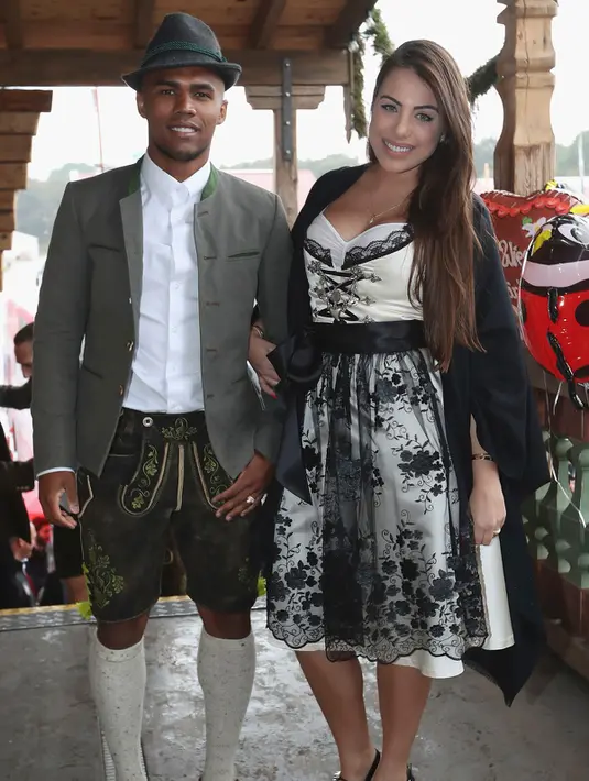 Gelandang Bayern Munchen, Douglas Costa bersama istrinya, Luisa Ramos berpose saat menghadiri Festival Oktoberfest di Munich, Jerman, (2/9). (REUTERS/Alexander Hassenstein)