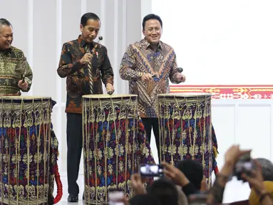 Presiden Joko Widodo (tengah) didampingi Gubernur Bank Indonesia Perry Warjiyo dan Kepala Bekraf Triawan Munaf (kiri) memukul gendang Beleq sebagai tanda peresmian pembukaan pameran Karya Kreatif Indonesia (KKI) 2019 di JCC Senayan, Jumat (12/7/2019). (Liputan6.com/Angga Yuniar)