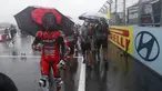 Tim mekanik dan kru kembali ke paddock saat hujan deras sebelum Race 1 World Superbike (WSBK) di Pertamina Mandalika International Street Circuit, Lombok Tengah, Nusa Tenggara Barat, Sabtu (20/11/2021). Hujan deras memaksa Race 1 WSBK Mandalika ditunda pada 21 November. (AP Photo/Achmad Ibrahim)