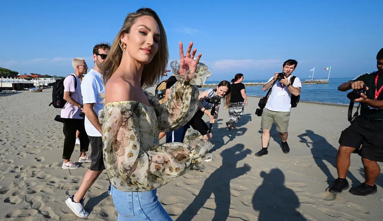 Model Afrika Selatan Candice Swanepoel menyapa awak media sebelum sesi pemotretan di pantai Lido menjelang pembukaan Festival Film Venesia ke-76 di Venice Lido, Italia (27/8/2019). (AFP Photo/Vincenzo Pinto)