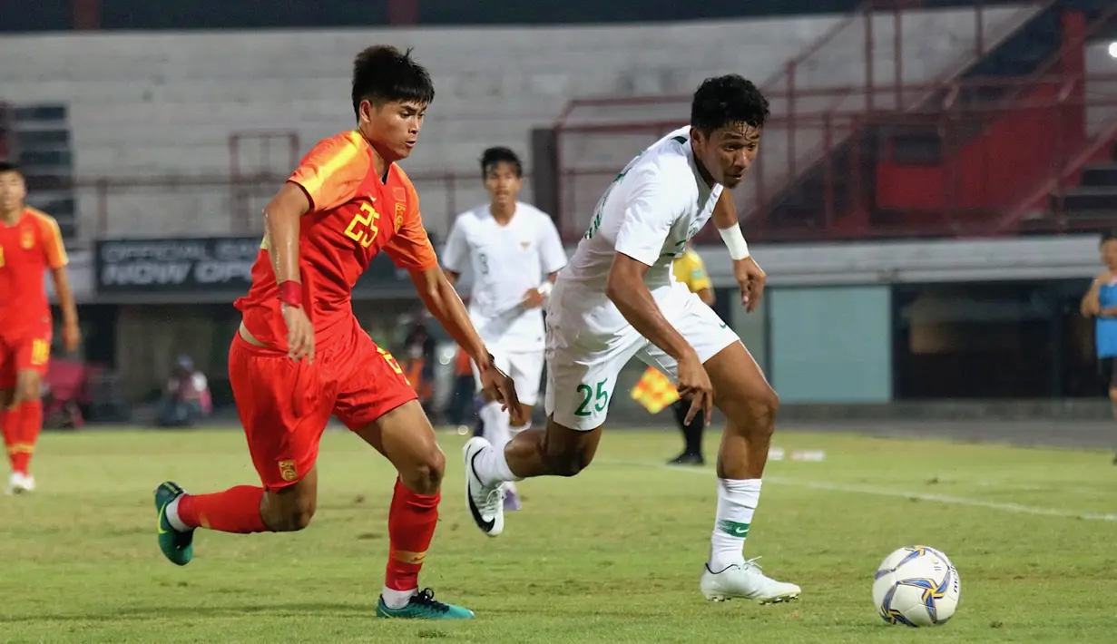 Striker China U-19, Tayier Xiaokaitijiang, berebut bola dengan striker Timnas Indonesia U-19, Serdy Ephy Fano Boky, pada laga ujicoba di Stadion I Wayab Dipta, Bali, Minggu (20/10). Indonesia kalah 1-3 dari China. (Bola.com/Aditya Wany)