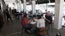 Pengunjung makan di luar di sebuah restoran di Tel Aviv, Israel pada Rabu (27/5/2020). Setelah lebih dari dua bulan ditutup untuk membendung penularan virus corona, restoran hingga kafe di Israel diizinkan dibuka kembali hari Rabu, 27 Mei. (AP Photo/Sebastian Scheiner)