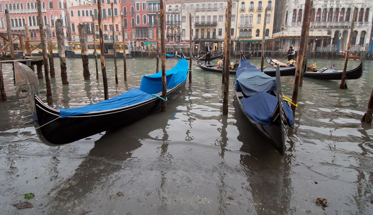 Gondola berlabuh di sepanjang kanal saat air surut di Venesia, Italia, 21 Februari 2023. Masalah di Venesia dipicu pada kombinasi faktor kurangnya hujan, sistem tekanan tinggi, bulan purnama dan arus laut. (AP Photo/Luigi Costantini)
