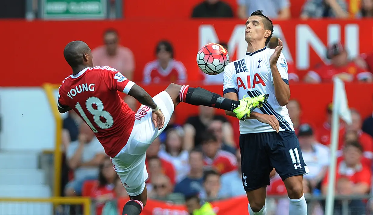 Pemain Spurs, Erik Lamela (kanan) berebut bola dengan pemain MU, Ashley Young dalam pertandingan di Stadion Old Trafford, Inggris. Sabtu (8/8/205). (EPA/Peter Powell)
