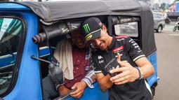 Momen keakraban Franco Morbidelli dengan pengemudi Bajaj sebelum menjajal perjalanan menggunakan bajaj pada Selasa, (30/09/2025). (Dok.Pertamina Lubricants)