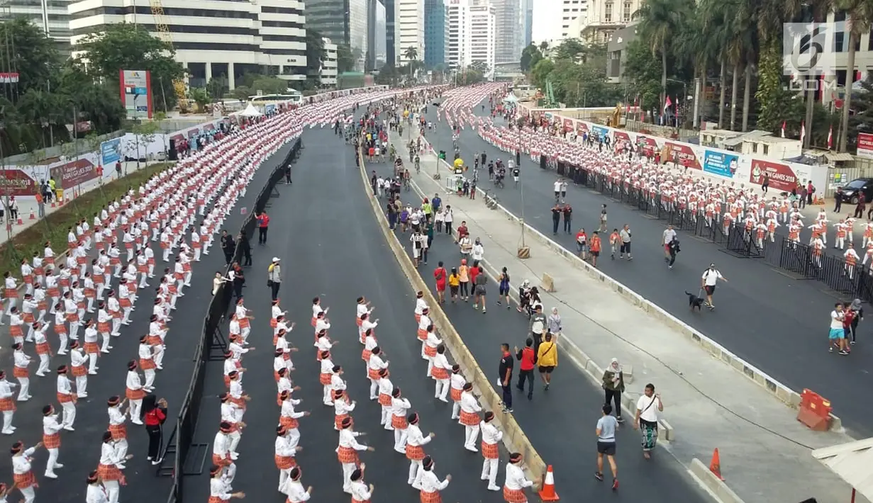 Ribuan peserta mengikuti pemecahan Guinness World Record tari Poco-poco di sepanjang Jalan MH Thamrin-Sudirman, Jakarta, Minggu (5/8). Acara tari Poco-poco ini tersebar dari Lapangan Silang Monas hingga Semanggi. (Liputan6.com/Pool/Biro Pers Setpress)