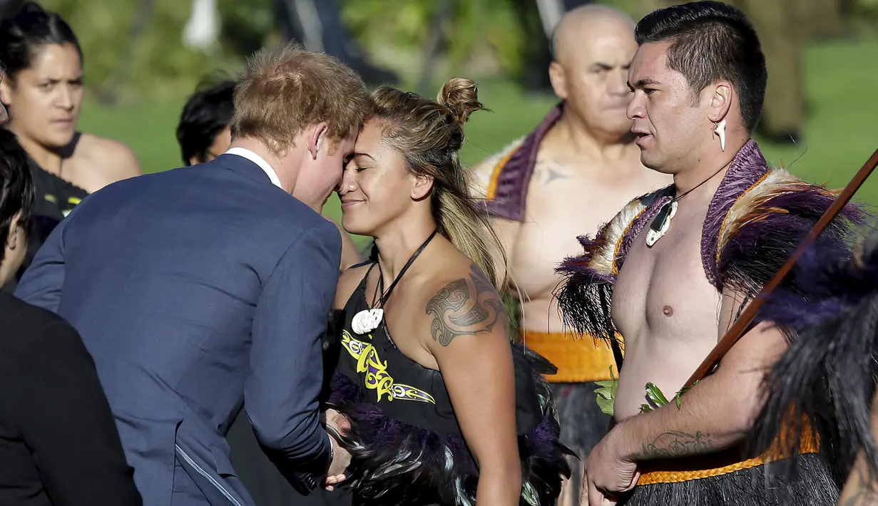 Pangeran Harry melakukan salam hongi pada seorang wanita suku Maori saat kunjungan selama seminggu ke Selandia Baru, Sabtu (9/5/2015). Salam ini terbilang unik karena dilakukan dengan cara menempelkan kedua kening kepala. (REUTERS/Anthony Phelps)
