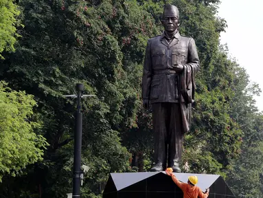 Pekerja membersihkan patung Presiden RI 1 Soekarno di depan Pintu 5 GBK, Jakarta, Rabu (11/7). Pemasangan Patung tersebut dilakukan jelang perhelatan bergengsi Asian Games pada 18 Agustus 2018 di Jakarta dan Palembang. (Liputan6.com/Johan Tallo)