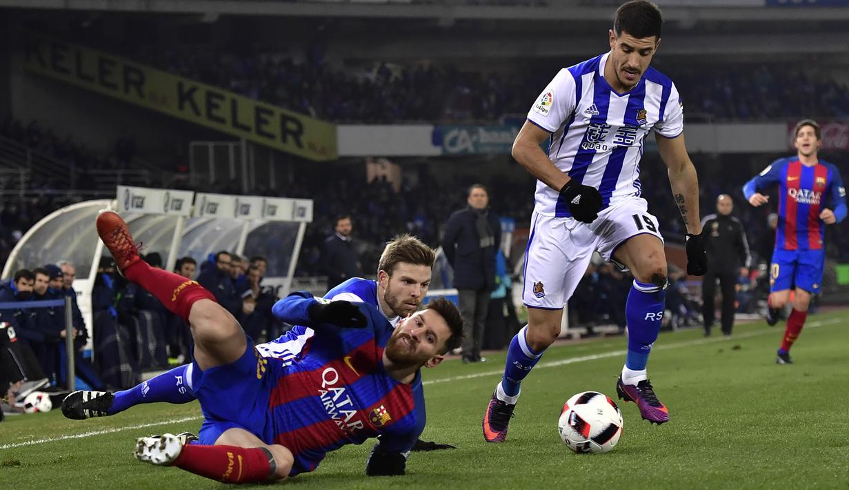 Bintang FC Barcelona, Lionel Messi terjatuh saat dihadang dua pemain Real Sociedad pada laga prempat final Copa Del Rey di Anoeta stadium, San Sebastian,  Kamis (19/1/2017). Barcelona menang tipis 1-0.  (AP/Alvaro Barrientos)