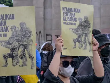 Para mahasiswa menunjukkan plakat bertuliskan “Kembalikan Tentara ke Barak” dalam sebuah protes menentang Revisi Undang-Undang Tentara Nasional Indonesia (RUU TNI) di depan gedung DPR di Jakarta pada tanggal 20 Maret 2025. (BAY ISMOYO/AFP)