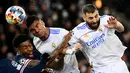 Bek Paris Saint Germain (PSG) Presnel Kimpembe (kiri) berebut bola dengan pemain Real Madrid Casemiro dan Karim Benzema pada leg pertama babak 16 besar Liga Champions di Stadion Parc des Princes, Rabu dini hari WIB (16/2/2022). PSG susah payah kalahkan Real Madrid 1-0. (FRANCK FIFE / AFP)