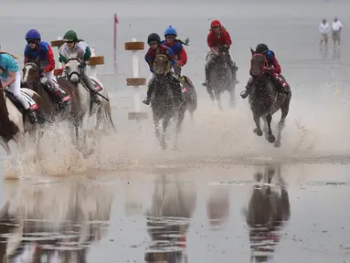 Sejumlah peserta memacu kudanya di atas lumpur saat berkompetisi di Wadden Race, Lower Saxony, Jerman, Minggu (12/7/2015).Para peserta bersaing untuk menjadi yang terdepan. (REUTERS/Fabian Bimmer)