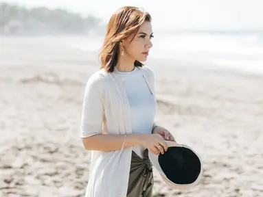 Selain jogging, Najwa Shihab juga memiliki hobi traveling. Kesukaan Najwa Shihab saat traveling ini terbukti saat ia berlibur ke pantai. Dengan outfit putih, Najwa Shihab terlihat begitu menikmati indahnya pemandangan pantai. (Liputan6.com/IG/@najwashihab)