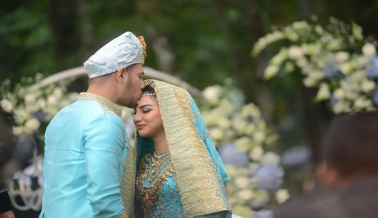 Akad nikah yang digelar di Pine Hill, Kabupaten Bandung, Jawa Barat ini mengusung konsep adat Minang. Pakaian yang digunakan oleh Ammar dan Irish memiliki sentuhan warna biru dan juga emas.  (Kapanlagi.com/Bayu Herdianto)