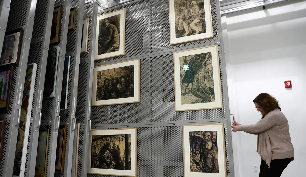 Seorang pekerja yang bernama Laura Seylar menunjukan gambar-gambar yang dibuat para korban Holocaust yang menjadi koleksi US Holocaust Memorial Museum di Bowie, Maryland (24/4). (AP Photo/Carolyn Kaster)