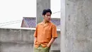 Padu padan warna semarak yang serasi dari Abidzar. Ia mengenakan kemeja lengan pendek berwarna oranye yang dipadu cargo pants hijau army. [Foto: Instagram/abdizar73]
