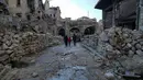 Sebuah keluarga berjalan diantara reruntuhan bangunan pasar lama di kota tua Aleppo, Suriah (21/1). Pada tahun 1986, kota kuno Aleppo dinyatakan sebagai situs warisan dunia UNESCO. (AP Photo / Mstyslav Chernov)