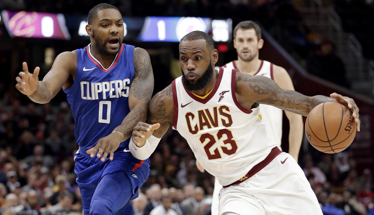 LeBron James (23) menggiring bola melewati adangan pemain Los Angeles Clippers, Sindarius Thornwell (0) pada laga NBA basketball game di Quicken Loans Arena, Cleveland, (18/11/2017), Cavs menang 118-113. (AP/Tony Dejak)