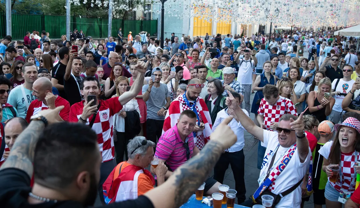 Para fans Kroasia bersorak jelang final Piala Dunia 2018 antara Prancis melawan Kroasia di Nikolskaya street dekat Kremlin di Moskow, Rusia, (13/7). (AP Photo/Pavel Golovkin)