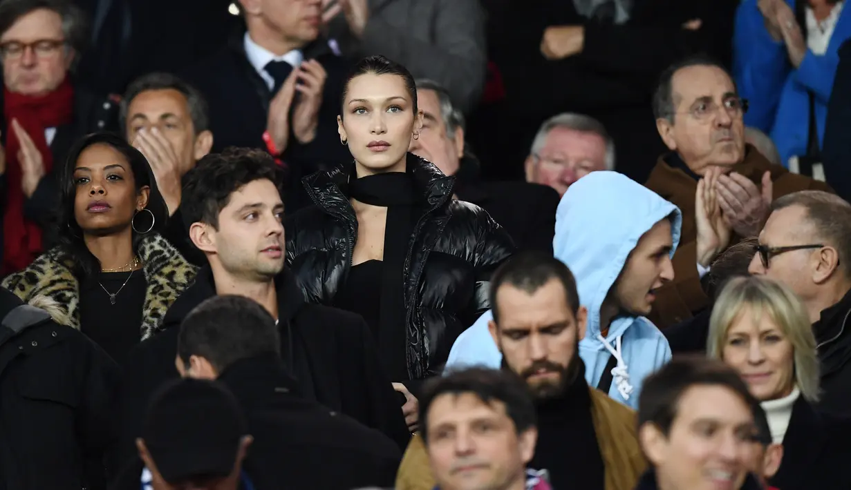 Model AS Bella Hadid menonton PSG melawan Real Madrid dalam pertandingan Liga Champions leg kedua di stadion Parc des Princes di Paris di (6/3). Pertandingan ini dimenangkan Madrid dengan skor 2-1 atas PSG. (AFP Photo/Franck Fife)