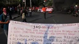 Puluhan massa yang tergabung dalam Jaringan aksi Solidaritas Membela Rakyat (JAS MERAH) membentangkan spanduk yang berisi tuntutan pembatalan UU Pilkada, Jakarta, (2/10/14). (Liputan6.com/Johan Tallo)