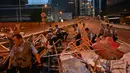 Petugas polisi membersihkan barikade yang dibuat demonstran setelah aksi menolak RUU ekstradisi di Hong Kong (13/6/2019). Aksi tersebut berujung bentrok antara polisi dan warga dimana puluhan ribu orang memblokir jalan-jalan di kota tersebut. (AFP Photo/Hector Retamal)