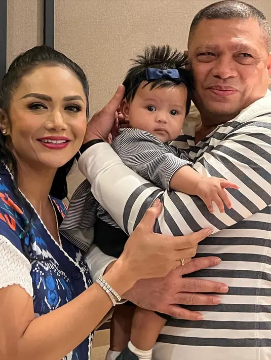 Entah disengaja atau tidak, Baby Amina dan Raul Lemos kompak mengenakan atasan lengan panjang berwarna dasar putih motif garis-garis hitam horizontal. Bedanya, garis-garis di baju Ameena lebih tipis dan rapat. Sementara Raul Lemos lebih tebal dan jarang. Penampilan Baby Ameena dipermanis bando pita biru tua nan mungil. Raul Lemos menggendong dengan penuh kasih sayang. (Foto: Dok. Instagram @krisdayantilemos).