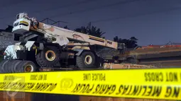 Sebuah truk berplat nomor B 9026 BEA menabrak Jembatan Penyeberangan Orang (JPO) di KM 7 Tol BSD, Tangerang Selatan, Minggu (15/5) malam. Trailer itu membawa crane berwarna putih dari arah BSD dengan tulisan P&H di badan crane. (Liputan6.com/Helmi Afandi)