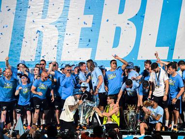Manchester City mendapat sambutan yang hangat dari puluhan ribu penggemar ketika kembali ke kota Manchester untuk melakukan parade Treble Winners, Selasa (13/6/2023) dini hari WIB. (AFP/Oli Scarff)