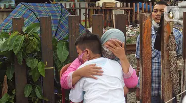 Seorang ibu memeluk anaknya saat aksi mencuci kaki ibu secara massal di Kelurahan Duri Pulo, Jakarta, Rabu (21/12/2021). Aksi yang diikuti 500 peserta ini bertujuan meningkatkan rasa cinta kasih kepada ibu dan dilakukan dalam rangka memeriahkan Hari Ibu. (Liputan6.com/Herman Zakharia)
