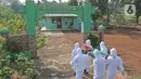 Petugas Satpol PP Kabupaten Bogor yang mengenakan pakaian hazmat menggotong warga pelanggar PSBB di kawasan Stadion Pakansari, Kabupaten Bogor, Jawa Barat, Minggu (6/9/2020). Pemkab Bogor menerapkan sanksi denda Rp 100 ribu serta sanksi sosial bagi pelanggar PSBB. (Liputan6.com/Herman Zakharia)