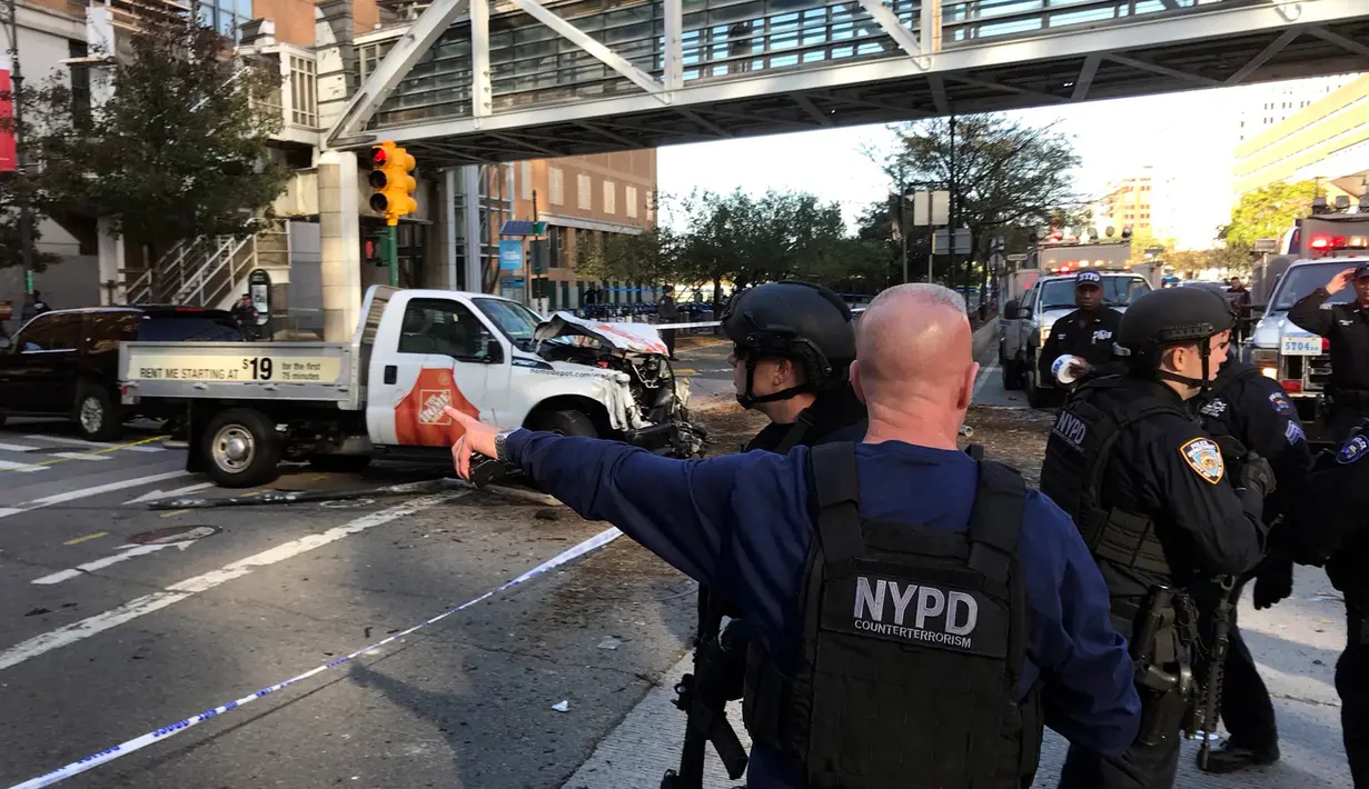 Polisi NYPD mendatangi lokasi sebuah truk yang menabrak pejalan kaki dan pesepeda di Lower Manhattan, New York, Selasa (31/10). Lokasi serangan ini berdekatan dengan World Trade Center (WTC) yang jaraknya berkisar 983 meter. (Martin Speechley/NYPD via AP)