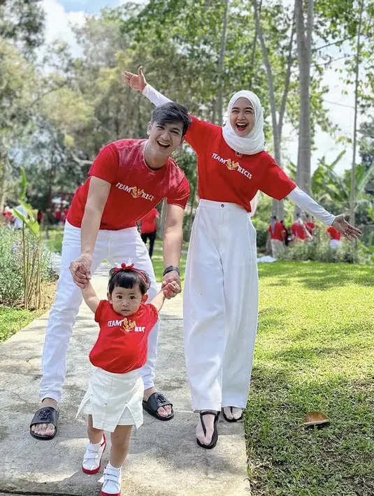 <p>Ria Ricis bersama suami dan anaknya kompak mengenakan baju atasan merah dengan bawahan putihnya. [@riaricis1795]</p>