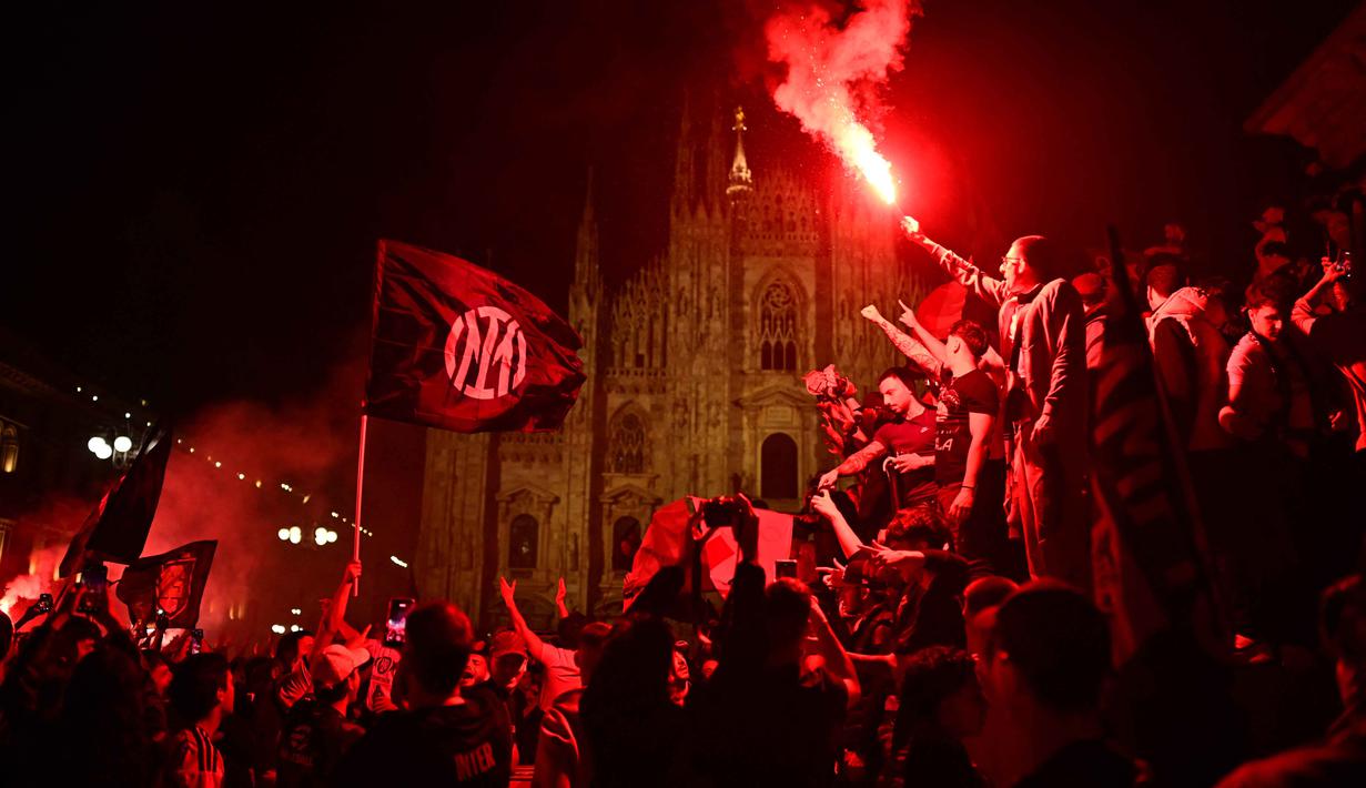 Mereka datang dari berbagai penjuru untuk merayakan keberhasilan tim kesayangan mereka kembali menjadi penguasa Italia. Tampak dalam foto, para pendukung Inter Milan merayakan gelar juara Serie A musim 2025/2026 atau scudetto ke-21 di Piazza Duomo, Milan, Italia, Minggu (3/4/2026) malam waktu setempat atau Senin (4/5/2026) dini hari WIB. (PIERO CRUCIATTI/AFP)