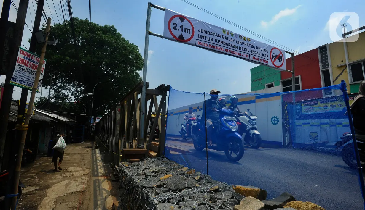 Pengendara motor melintas di jembatan darurat atau bailey Cikereteg di Jalan Raya Bogor-Sukabumi, Bogor, Jawa Barat, Senin (13/3/2023). Sepanjang 40 meter dan lebar lima meter, jembatan berkerangka besi dengan alas kayu itu sudah rampung sejak tadi pagi. (merdeka.com/Arie Basuki)