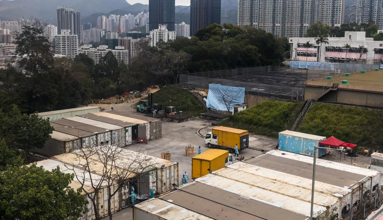 Pekerja (kiri) memindahkan jenazah dari truk ke kontainer berpendingin di Rumah Sakit Umum Fu Shan, Hong Kong, Rabu (16/3/2022). Kasus COVID-19 terburuk yang melanda Hong Kong menimbulkan kepanikan serta membuat rumah sakit dan kamar jenazah penuh. (DALE DE LA REY/AFP)