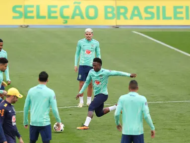 Penyerang Brasil, Vinicius Junior (kanan) bersama rekan setimnya menghadiri sesi latihan menjelang pertandingan sepak bola FIFA Matchday melawan Spanyol di tempat latihan Ciudad Real Madrid di Valdebebas pinggiran kota Madrid, pada tanggal 25 Maret 2024. (Pierre-Philippe MARCOU/AFP)