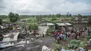 Sejumlah warga melihat proses pencarian para korban yang tertimbun gunungan sampah longsor di ibu kota Mozambik, Maputo,  Senin (19/2). Hujan lebat diperkirakan merupakan pemicu insiden di distrik miskin Maputo itu. (MAURO VOMBE / AFP)